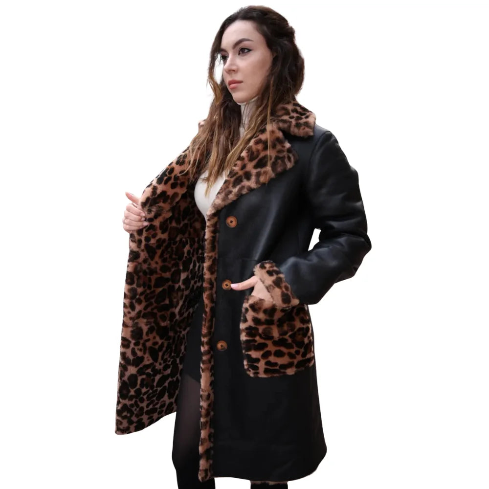 A model wearing the oversized Seraphina leopard print leather coat styled with black trousers, demonstrating the mid-thigh length and relaxed fit.