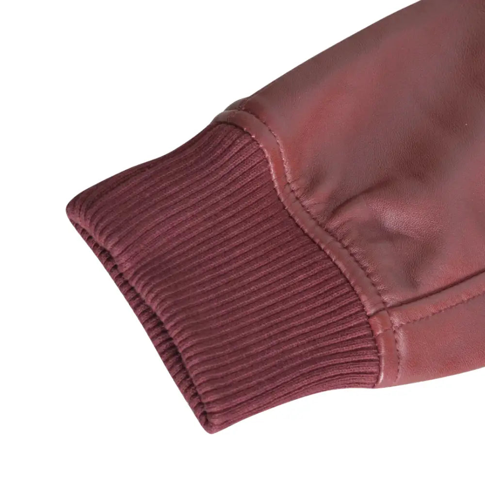 Detailed view of the ribbed knitted cuffs and hem of Justin's Burgundy A2 Bomber leather jacket, showing the jacket’s stylish and comfortable fit.