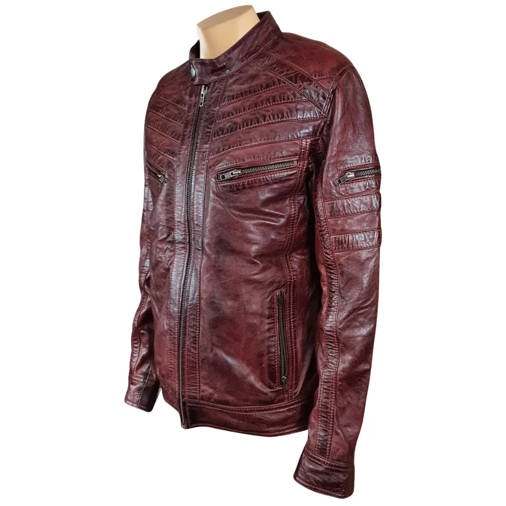 Detailed view of the burnished burgundy leather finish and vertical zippered chest pocket on Charley Ellwood’s moto jacket, white background.