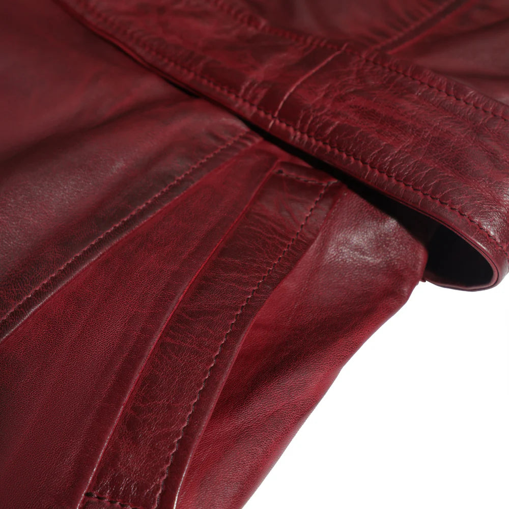 Close-up of a red leather jacket showcasing pockets with visible stitching on a white background