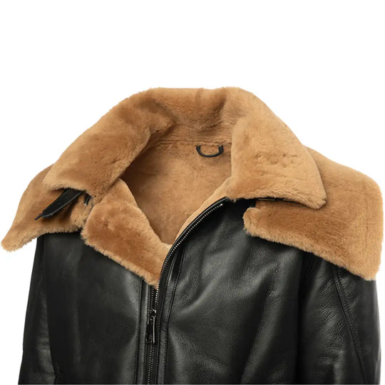 Close-up of the buckle detail on the black Aviator shearling jacket, showcasing the tan sheepskin collar.