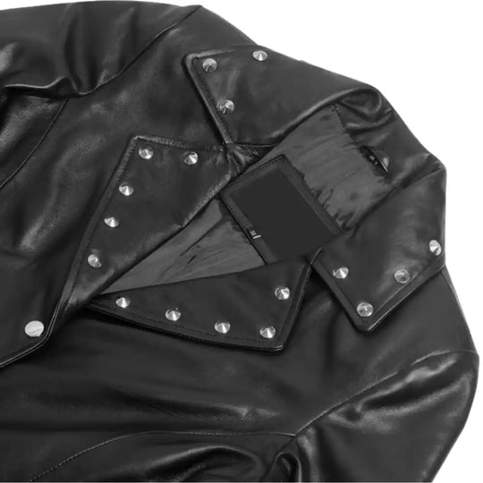 Close-up of the neckline and shoulder construction with studded details of the Jennifer asymmetrical dress on a white background.