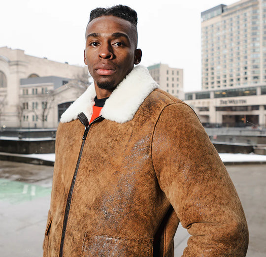 Model wearing Lucian's distressed brown A2 bomber shearling jacket in a street-style setting with modern urban background.