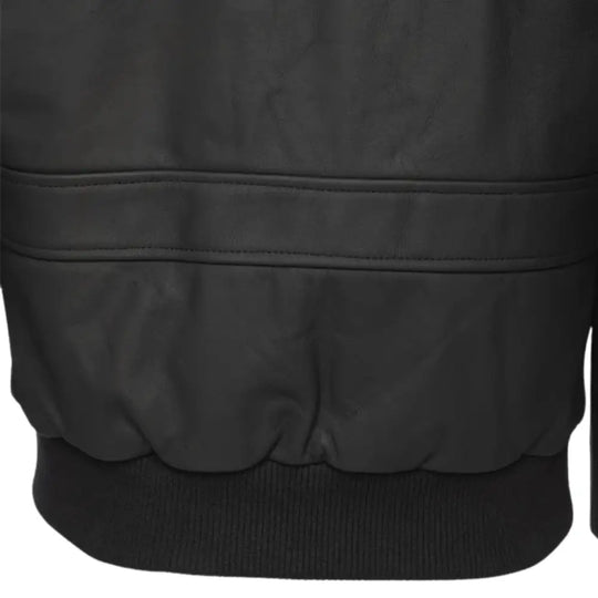 Close-up of the cuff and wrist belt detail on a matte black A2 bomber leather jacket worn by a model