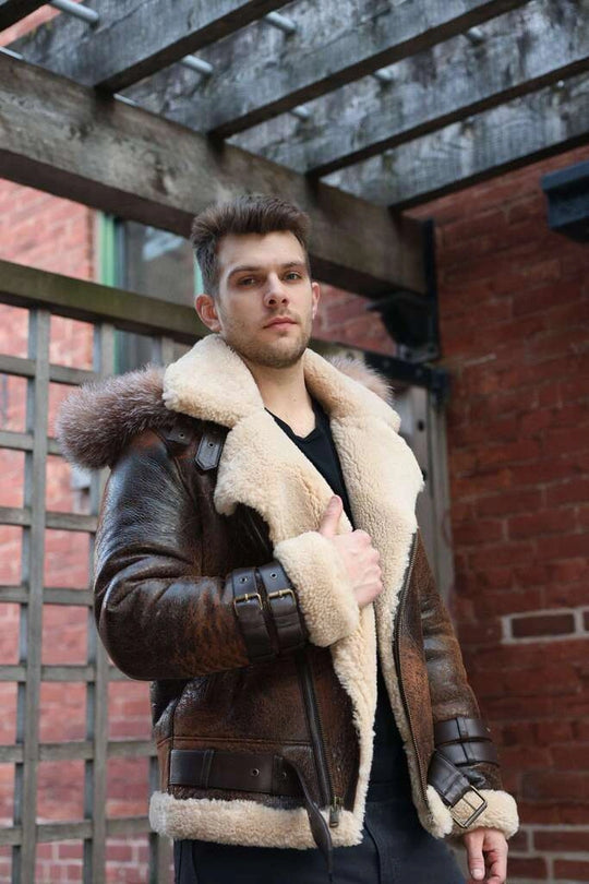 Man wearing Rocco vintage brown aviator shearling jacket with fur lining against a brick wall.