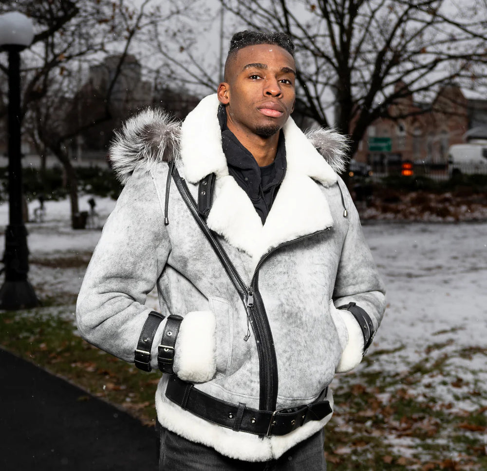Lifestyle photoshoot of a man wearing the Rocco vintage distressed grey leather aviator jacket for a rugged, in a snowy outdoor setting.