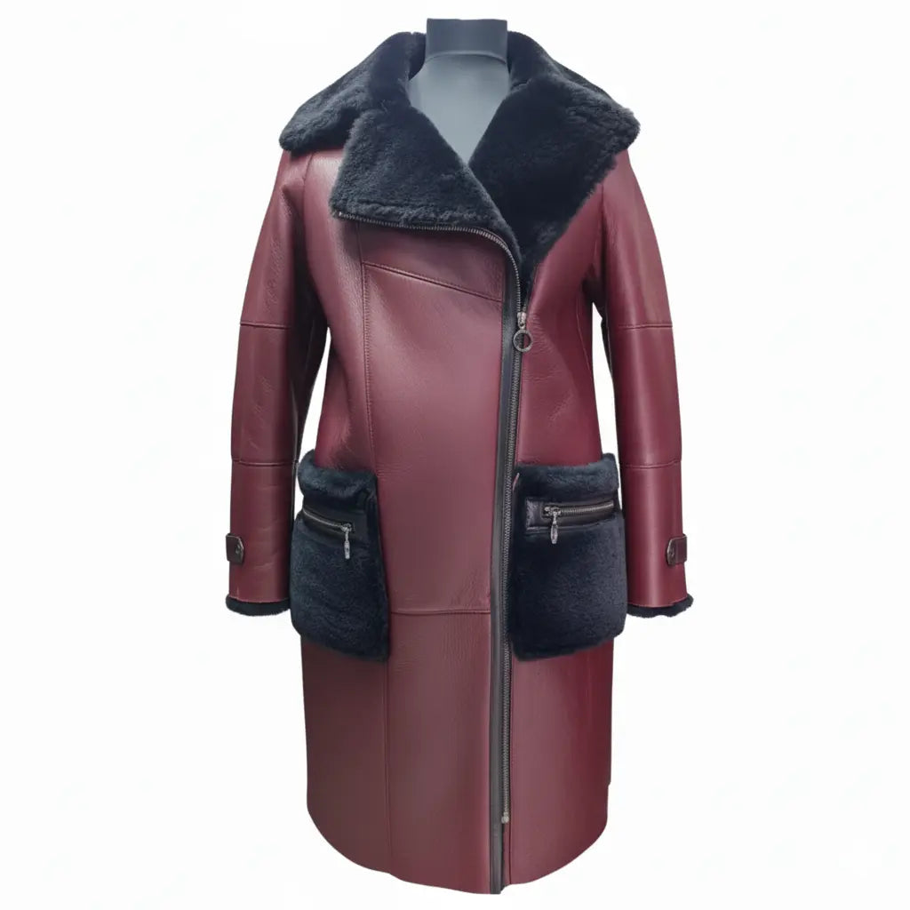 A full-length front view of Samira's burgundy shearling trench coat for women, featuring a large black fur lapel collar, asymmetrical zipper closure, and oversized black fur-trimmed pockets with zippers on white background.