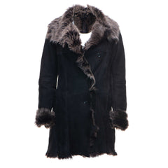 A black shearling sheepskin coat with a Toscana trim collar and buttoned closure. The coat features open cuffs and is displayed against a plain background.